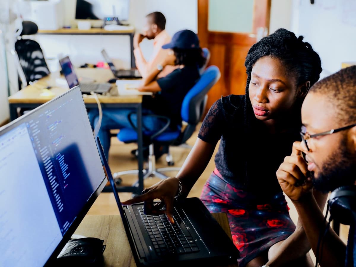 Two colleagues collaborating together at a computer screen