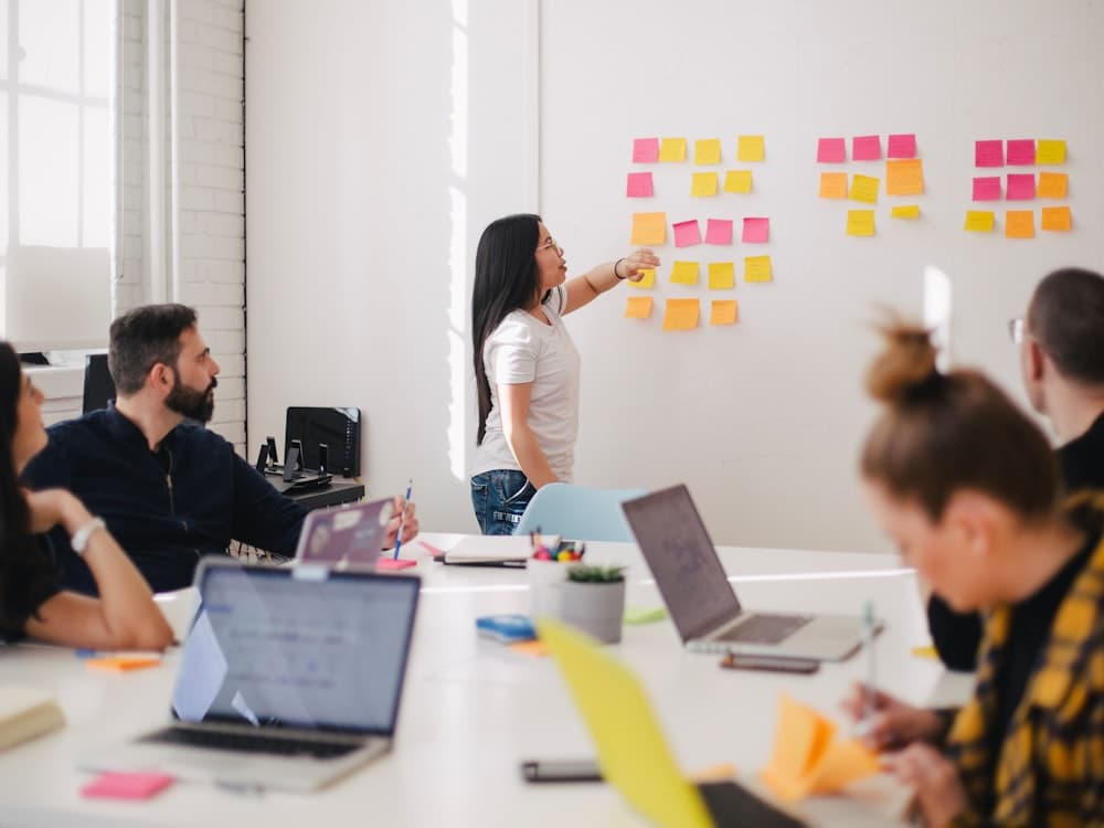 A small team gathered around a whiteboard for a focused discussion